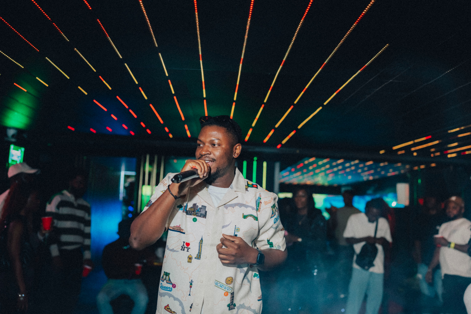 Mide Phresh performing under neon lights